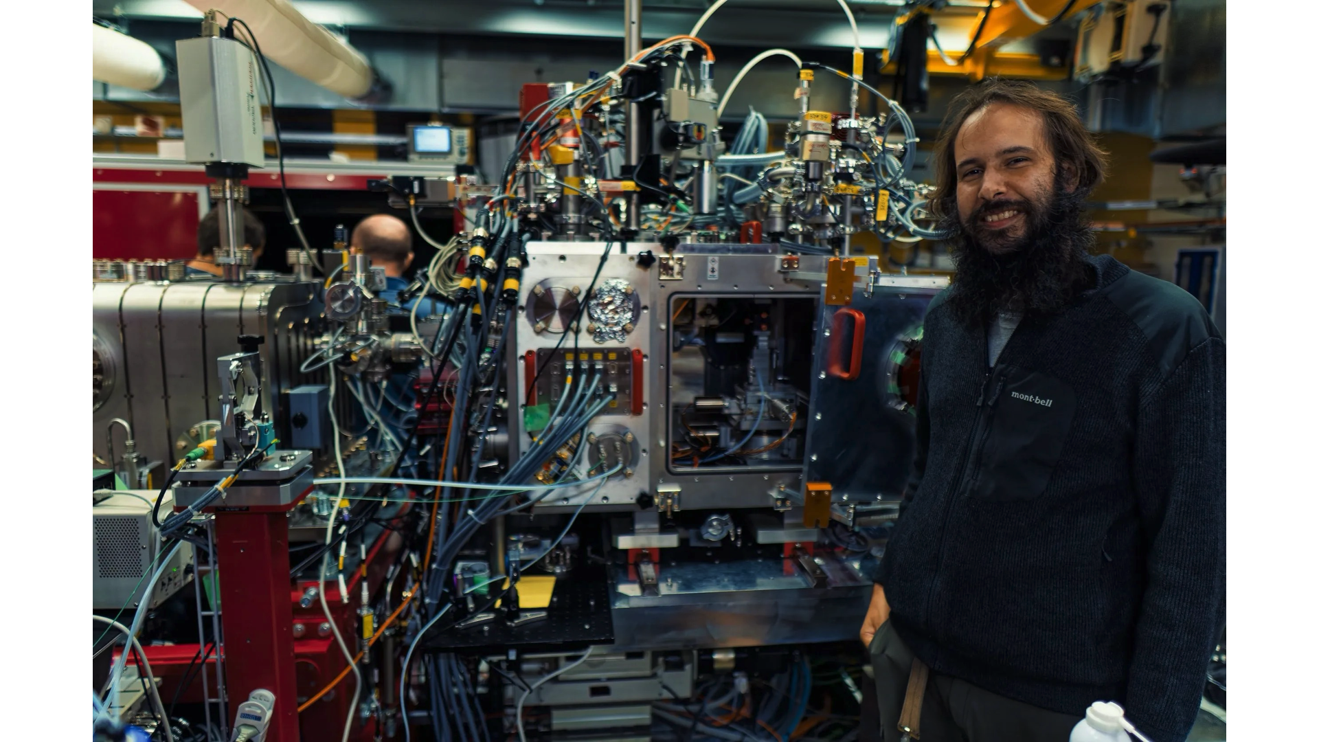 論文第一作者 Manuel Maestre-Reyna 博士，他旁邊的複雜設備是瑞士 XFEL 實驗站（SwissFEL Experimental Hutch），這台機器可以收集與輸出樣品的繞射資料。 圖｜Dr. Manuel Maestre-Reyna 提供